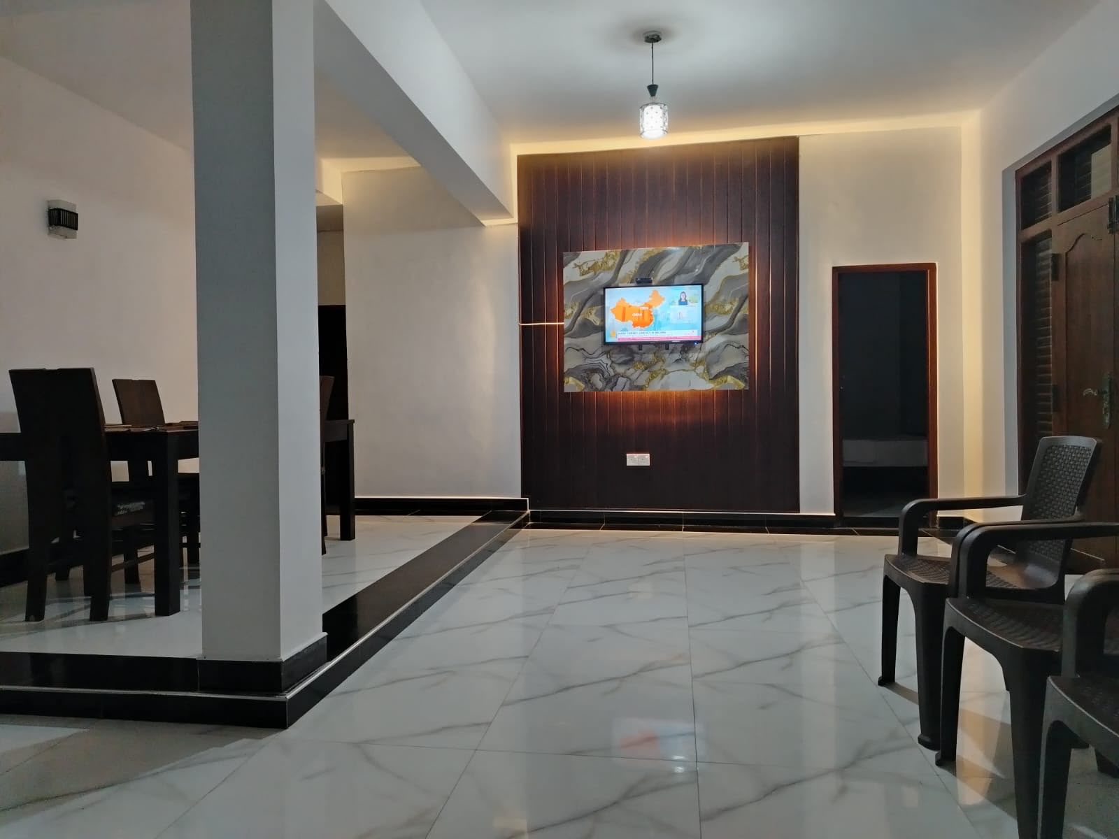 Living area with TV mounted on a decorative wood-paneled wall